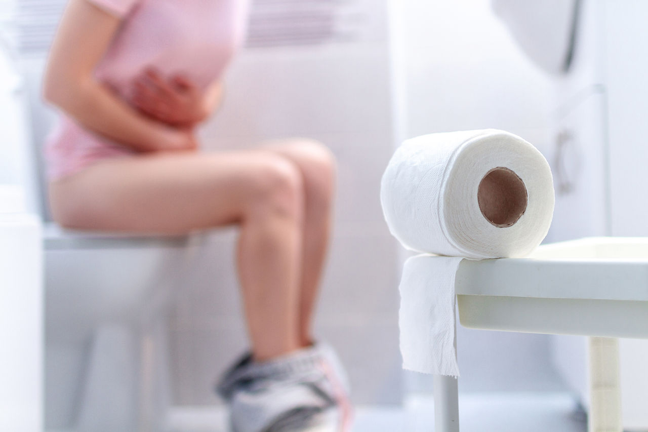 Ill, unwell woman suffering from diarrhea, constipation and cystitis at toilet. Stomach pain during PMS. Health care and pain concept ,Ill, unwell woman suffering from diarrhea, constipation and cyst