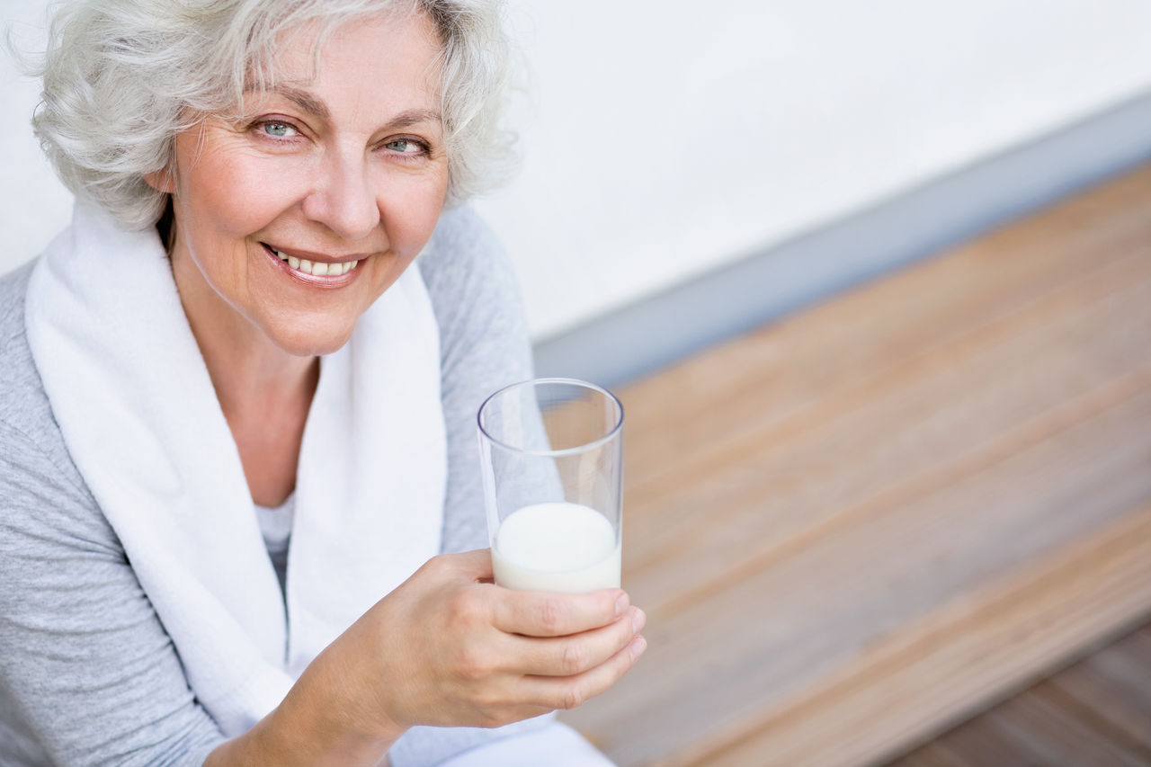 Seniorin mit einem Glas Milch